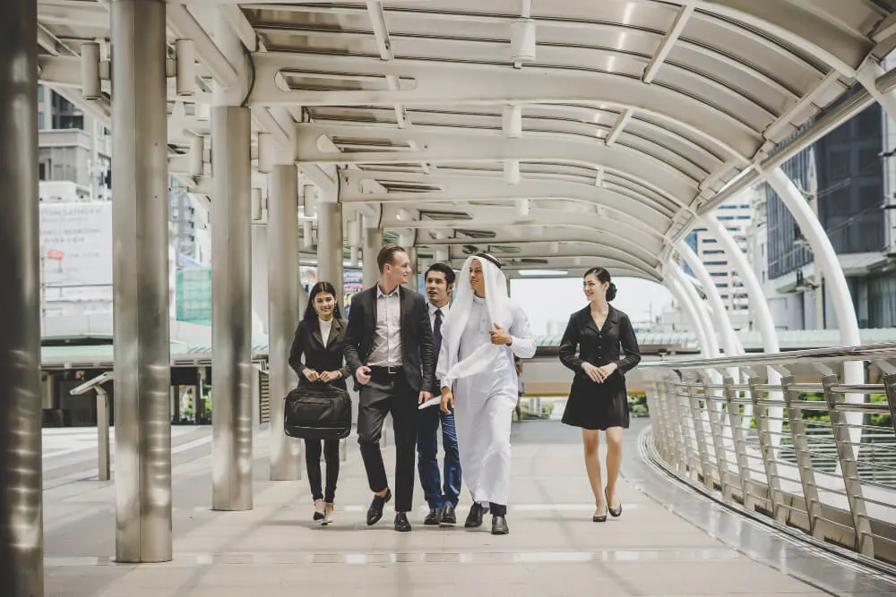 Mainland Company Formation in Dubai - Businesspeople walking in a modern pedestrian outdoor walkway.